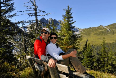 Wanderer sitzen auf einer Sitzbank im Zillertal