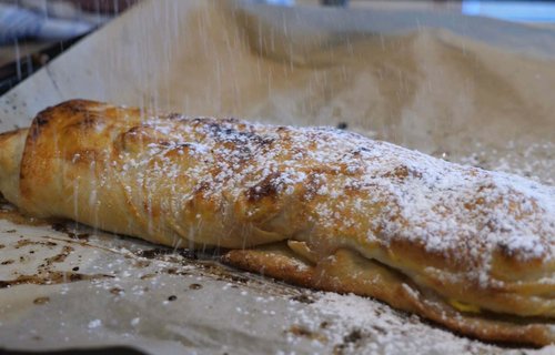 Apfelstrudel mit Staubzucker bestreuen